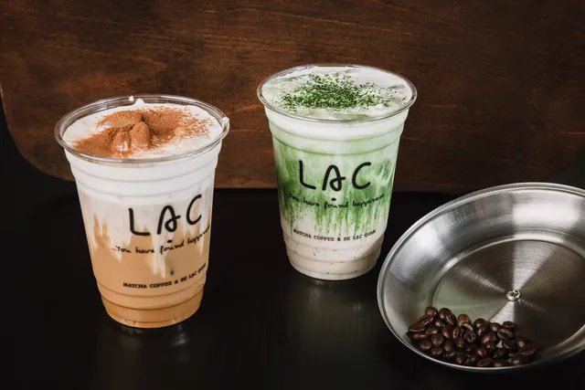 Iced Vietnamese coffee and hand-whisked matcha served side by side in Lạc Coffee cups