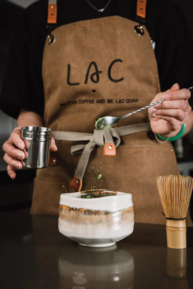Bowl of hand-whisked ceremonial matcha beside a chasen, foam still settling